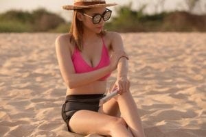 Girl on the Beach Putting Sunscreen On