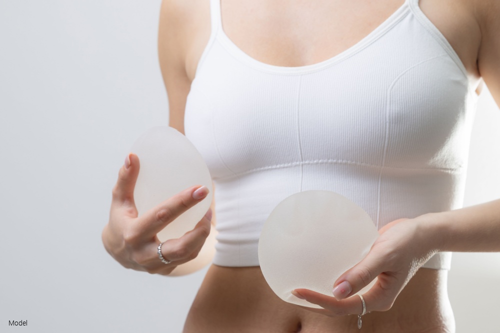 Woman holding silicone breast implants 